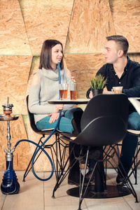 夫妇放松和吸烟水烟在咖啡酒吧