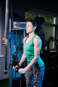 在健身房训练机与年轻健身女人锻炼