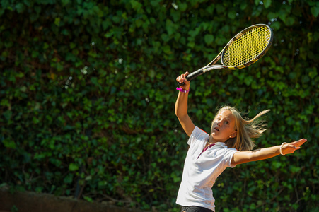 运动员用球拍在网球场上的女孩