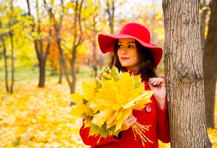秋天, 在公园散步时, 美丽的女人在黄色的叶子上的秋画像。积极的情绪和幸福的概念