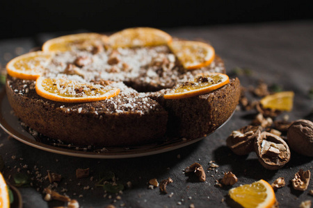 美丽和美味的巧克力蛋糕与橙色和坚果在黑暗的背景