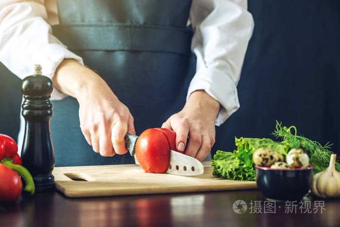黑围裙的主厨切菜.环保型烹饪产品概念