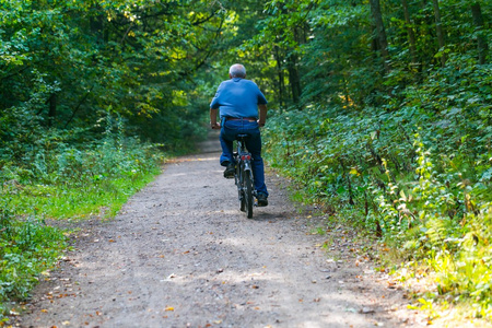 男子骑着自行车穿过夏季森林