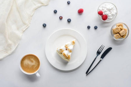 白色桌上有浆果和咖啡的美味蛋糕的顶级视图
