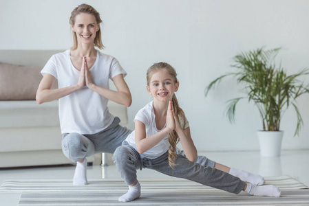 母亲和女儿在家里练习瑜伽