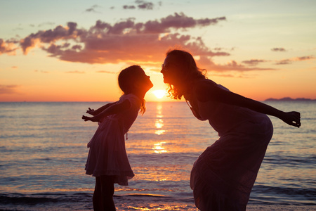 mor och dotter som spelar p stranden