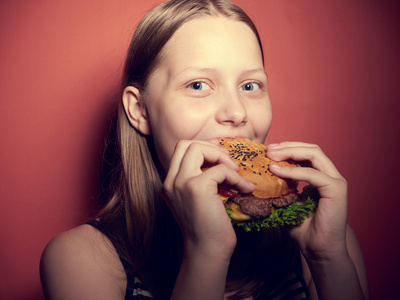 十几岁的女孩吃一个汉堡