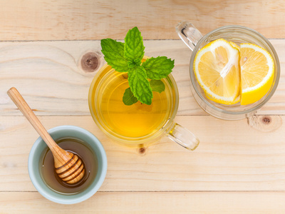 杯与新鲜绿薄荷 蜂蜜和柠檬在木头上的花草茶