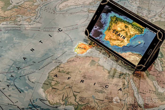 概念旅行。带卫星地图的平板电脑西班牙站在纸