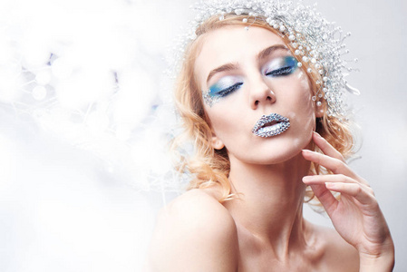 创意化妆和美容主题 一个年轻的女孩与蓝色冬季化妆工作室白色背景