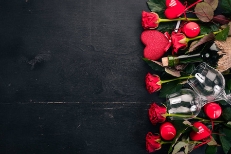 一瓶红酒和一束红玫瑰。情人节在木制背景上。顶部视图。文本的可用空间
