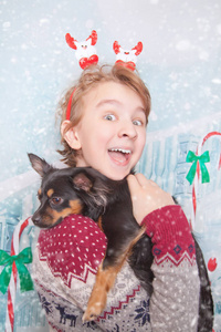 可爱的亲切的孩子男孩与他的黑色小狗朋友在圣诞节演播室