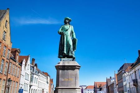 凡艾克和蓝蓝的天空，在布鲁日，比利时反对中世纪房屋外墙的雕像