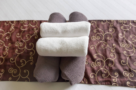 关闭酒店卧室的毛巾, 在酒店客房毛巾选择焦点, 白色酒店毛巾卷起在床上, 客房服务温泉