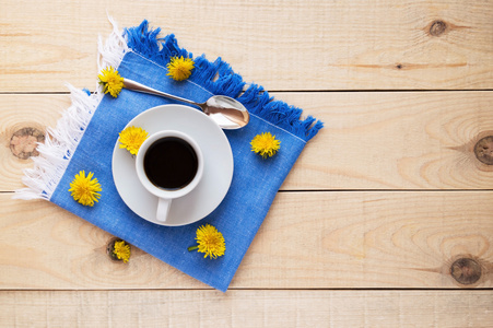 在蓝色的餐巾纸上咖啡一杯。春天的花朵。在顶视图
