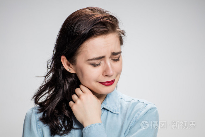 一个哭泣的年轻孤独的女子在灰色的肖像