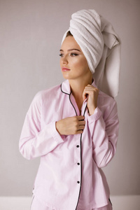 美丽的女士在粉红色的睡衣肖像站在她的头上的毛巾和朦胧的寻找预留孤立