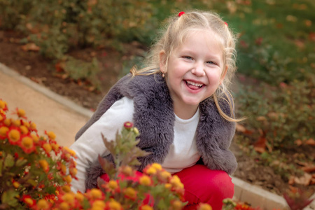 肖像快乐可爱的小女孩在花园里玩得开心