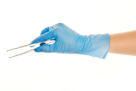 女医生的手在蓝色消毒的外科手术手套的密切联系对白色钳