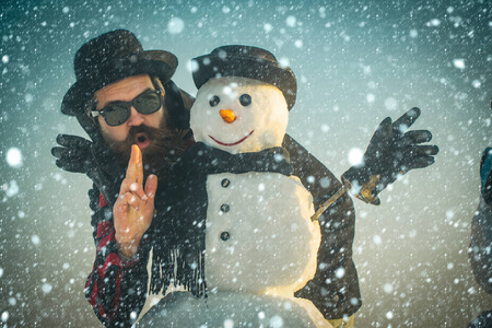 圣诞节男子和雪人在黑绅士帽子或间谍