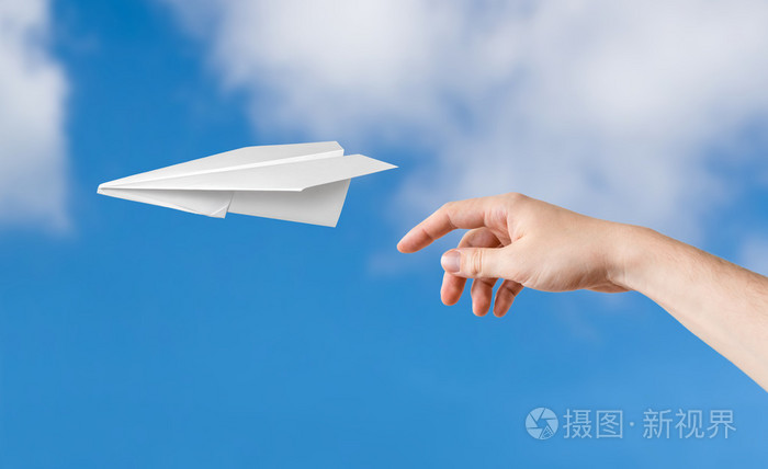 手投掷折纸纸飞机蓝蓝的天空背景上
