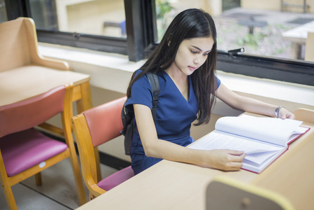 有吸引力的女性亚洲大学学生阅读书在天秤座