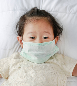 亚洲小女孩戴着防护面具躺在床上