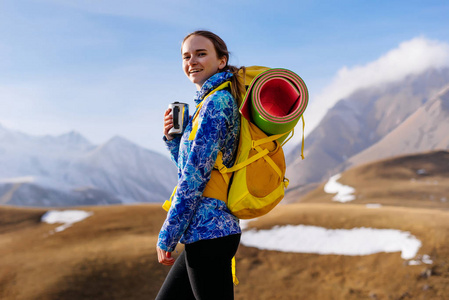 高山背景下的快乐女游客捧着一杯茶