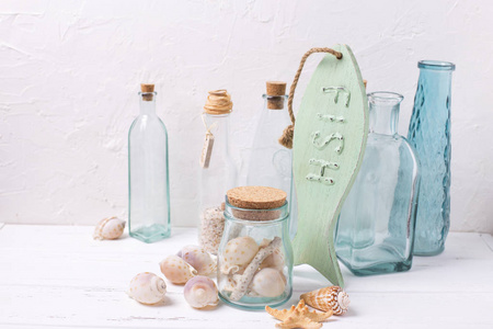 装饰的木制小鱼 瓶和壳白色带纹理的背景上