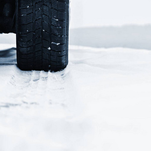 汽车在冬天。恶劣天气下下雪的路上的轮胎