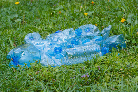 塑料瓶和瓶盖在公园，草地上的乱扔垃圾的环境