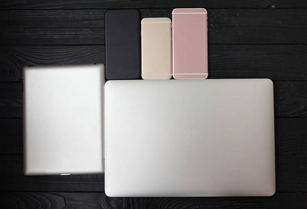 简约平躺在黑白笔记本电脑键盘上, 手机小工具上有质感的木桌背景亮亮。工作区顶部视图, 复制空间