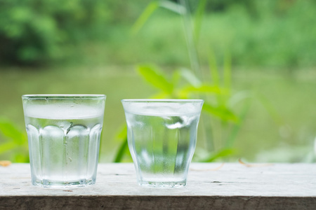 清凉的水在木桌上与湖背景