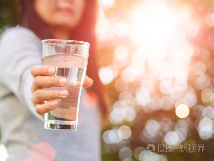 特写的女人手拿着一杯水