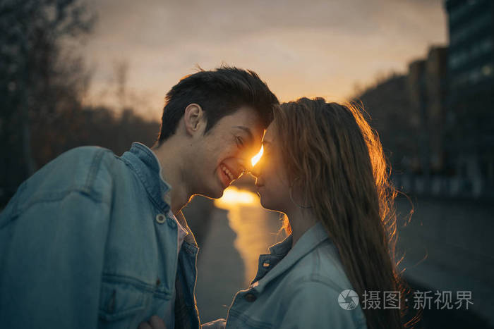 年轻的恋人在美丽的夕阳中接吻.情人节