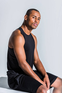 年轻的非洲裔美国运动员坐在灰色的摄像头看
