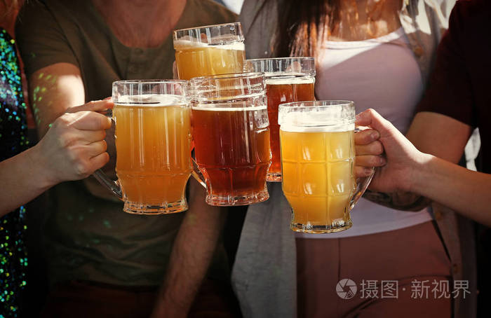 人们碰杯喝啤酒