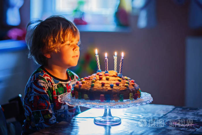 小小孩男孩庆祝他的生日和吹蜡烛蛋糕上