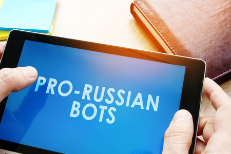 手持平板电脑的人用文字支持俄罗斯机器人。俄罗斯互联网宣传理念
