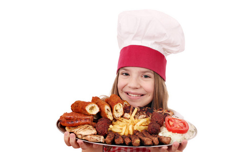 愉快的小女孩烹调与混合的烤肉在板材