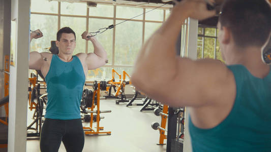 在健身房的镜子前锻炼的强壮的人