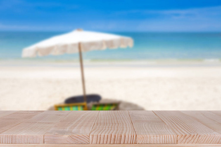 木桌上模糊蓝色的大海和白色的沙滩背景