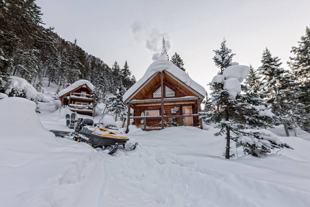 从房子小木屋在冬季森林与高山雪雪地