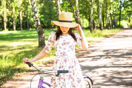 快乐漂亮的年轻女孩骑自行车在夏季公园。在城市愉快的放松时间。美丽的女人, 晴朗的日子