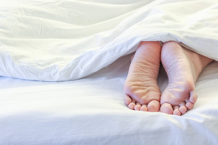 白色的床房间里熟睡中的女人的脚