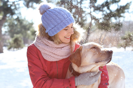 冬天的时候在户外的女人和可爱的狗的肖像。宠物与主人之间的友谊
