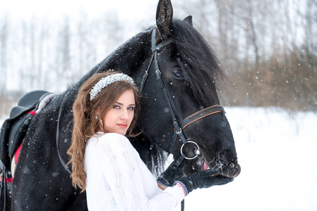 一个漂亮的女孩和一个英俊的种马，有一匹马的画像