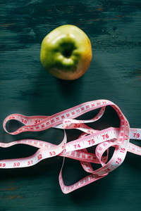 苹果和粉红色测量胶带在木桌特写, 减肥饮食概念
