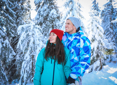 快乐的情侣享受着白雪皑皑的自然美景。寒假