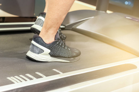 体育 健身 生活方式 技术和人们的观念封闭的男子双腿在与光眩光效果健身房的跑步机上行走